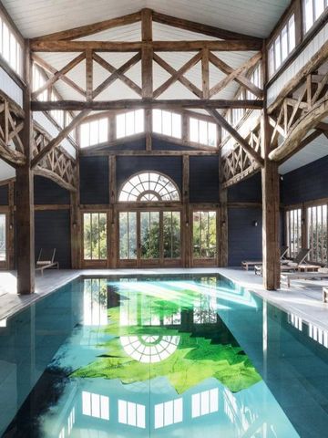 Großer, lichtdurchfluteter Innenpool mit Holzbalken und Panoramafenstern