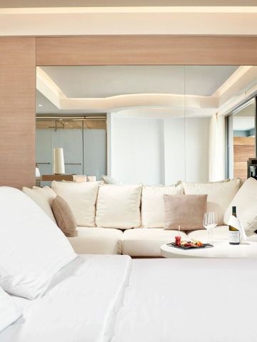 Elegantes Hotelzimmer mit Doppelbett, Sofa und Balkonblick. Moderner Stil.