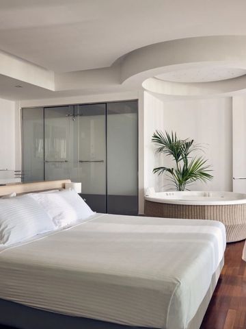 Großzügiges Schlafzimmer mit integriertem Whirlpool und moderner Einrichtung.