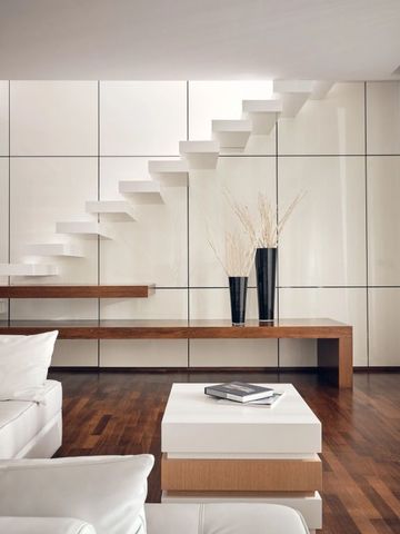 Moderne Suite mit Treppe und stilvoller Dekoration. Holzboden und elegante Möbel.