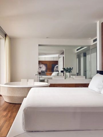 Geräumige Suite mit Bett und Whirlpool neben Glasfront