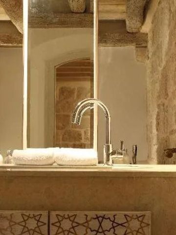 Elegant gestaltetes Badezimmer mit Steinwänden und luxuriösen Armaturen