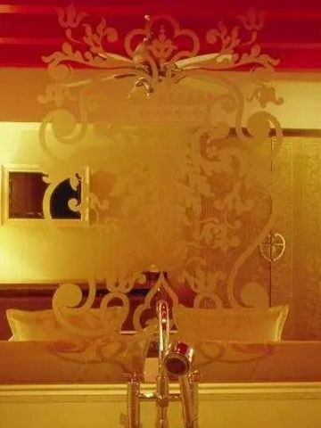 Prächtig verzierter Spiegel in luxuriös gestaltetem Raum mit warmem Licht