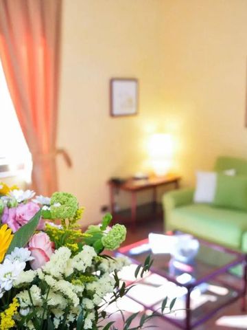 Helles Wohnzimmer mit grünem Sofa und Blumenschmuck auf dem Tisch.