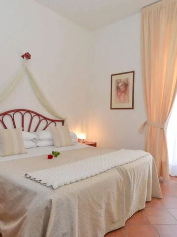 Zimmer mit gemütlichem Bett und dekorativen Vorhängen.