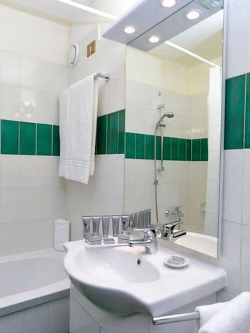 Modernes Badezimmer mit grünen Fliesen und eleganter Einrichtung.