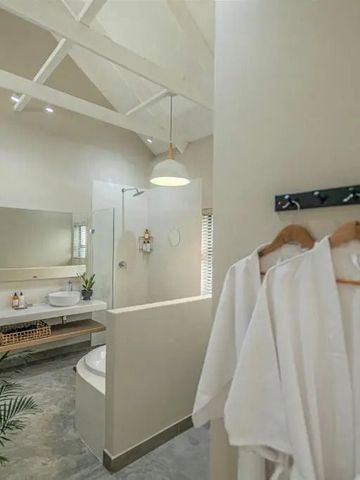 Modernes Badezimmer mit großen Spiegeln und Pflanzen