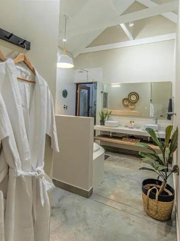 Luxuriöses Badezimmer mit Bademänteln und Pflanzen