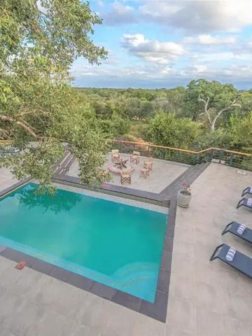 Ansicht von oben auf einen Infinity-Pool und Sonnenliegen