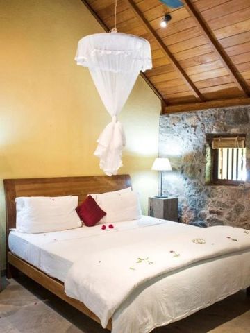 Gemütliches Schlafzimmer mit Holzbalkendecke und Steinelementen