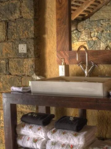 Stilvolles Badezimmer mit Steinmauer und modernen Waschbecken