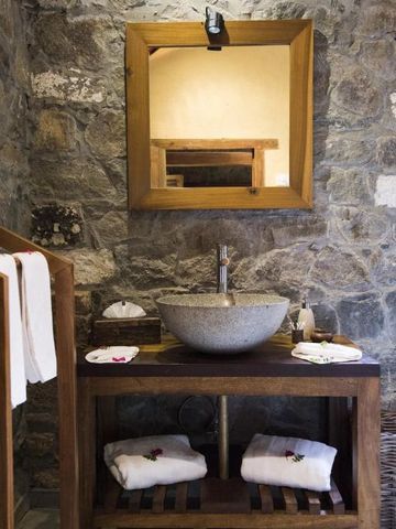 Luxuriöses Badezimmer mit Steinwänden und stilvollem Waschtisch im Hotel in Koslanda