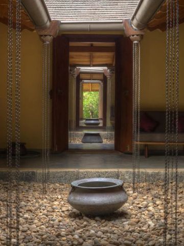 Zen-ähnlicher Innenhof mit Steinen und Wasserschalen in einem traditionellen Gebäude