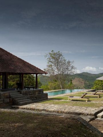Außenbereich mit Pool und Pavillon umgeben von Natur