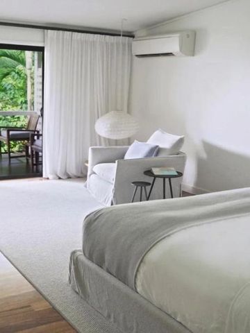 Elegantes Hotelzimmer mit Balkon und Blick auf tropisches Grün