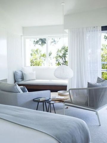 Gemütliche Sitzecke mit Ausblick im modernen Zimmer des Lizard Island Resort.