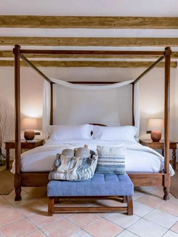 Elegantes Schlafzimmer mit Himmelbett und Holzbalkendecke