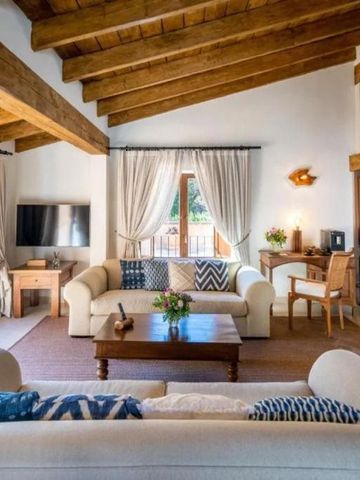 Geräumiges Wohnzimmer mit Holzbalkendecke und großer Fensterfront