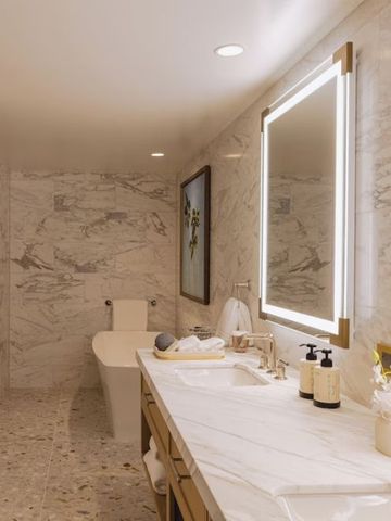 Luxuriöses Badezimmer mit edler Marmorverkleidung und großem Spiegel