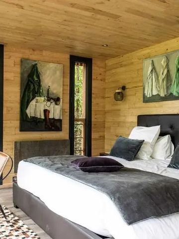 Gemütliches Schlafzimmer mit Kunstwerken, Holzwänden und bequemen Betten.