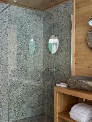 Edles Badezimmer mit Holzverkleidung und Steinwaschbecken.