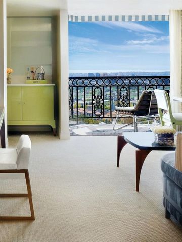 Suite mit Balkonblick auf die Stadt und stilvollem Wohnbereich.