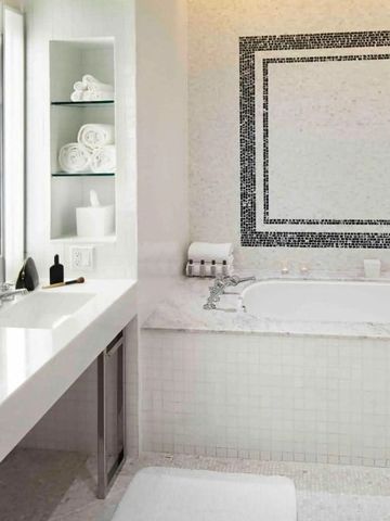 Helles Badezimmer mit luxuriöser Badewanne und stilvollen Fliesen.