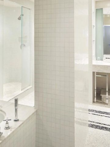 Modernes Badezimmer mit eleganter Dusche und weißem Dekor.