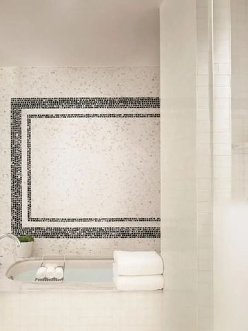 Hotelbad mit eleganter freistehender Badewanne und stilvollen Fliesen