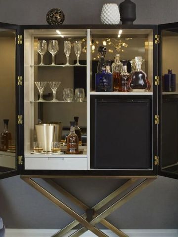 Hochwertiger Barbereich mit Gläsern und Spirituosenflaschen in edlem Schrank