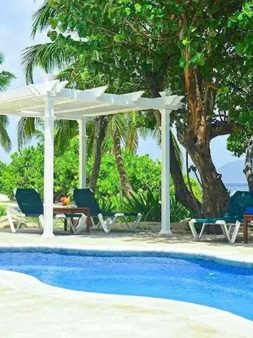 Pool mit Liegestühlen unter einer Pergola umgeben von üppigem Grün