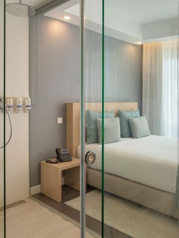 Modernes Hotelzimmer mit integriertem Bad hinter einer Glaswand