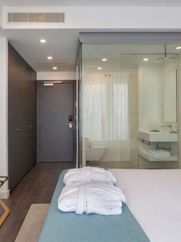 Modernes Hotelzimmer mit Glaswand und Doppelbett