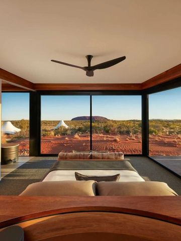 Elegantes Schlafzimmer mit großen Fenstern und Blick auf die Wüstenlandschaft