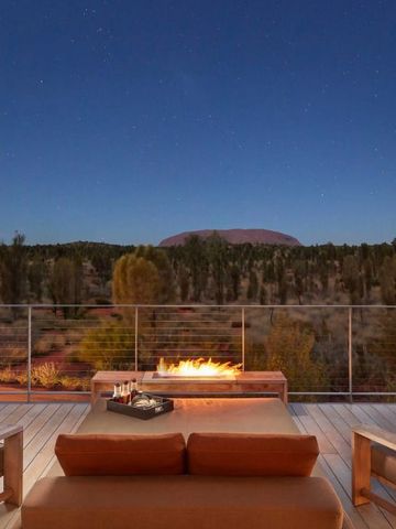 Terrasse mit Blick auf Uluru bei Nacht mit Feuerstelle und Liegestühlen