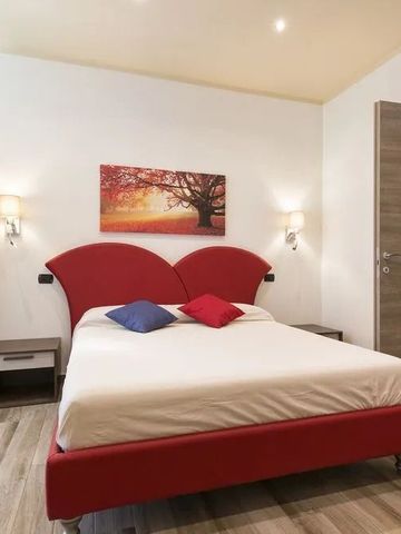 Zimmer mit Doppelbett, auffälligem Kopfteil und warmen Lichtakzenten