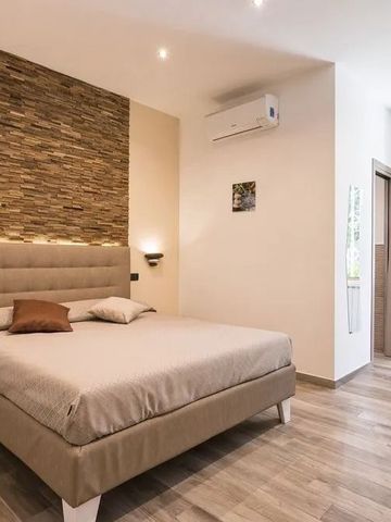 Komfortables Schlafzimmer mit Akzentwand in Natursteinoptik