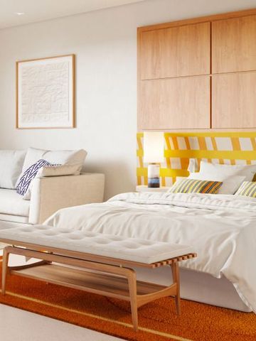 Modernes Schlafzimmer mit neutralen Farben und gemütlicher Sitzecke