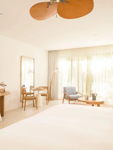 Großzügiges, helles Schlafzimmer mit Sitzbereich und Schreibtisch