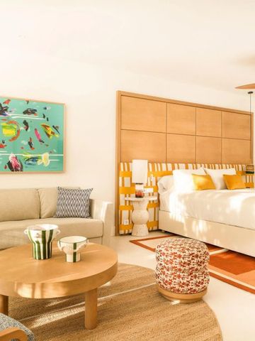 Helles Hotelzimmer mit Sofa und Kunst an der Wand