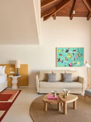 Elegantes und geräumiges Zimmer mit Holzbalkendecke und modernen Möbeln