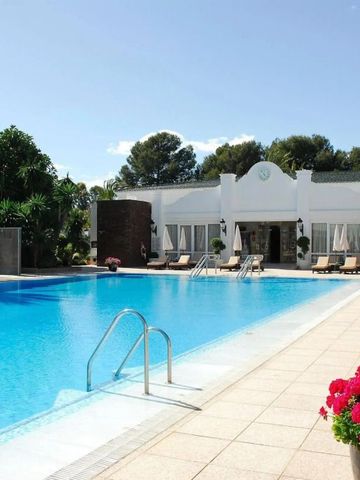 Großer Pool mit sonnigen Liegen und blühenden Blumen in einem luxuriösen Hotelgarten
