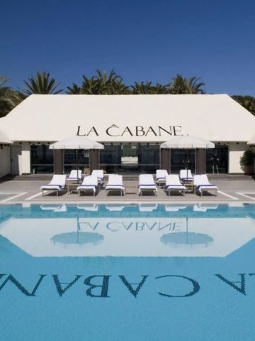 Stilvoller Beachclubbereich mit Pool und Sonnenliegen unter blauem Himmel