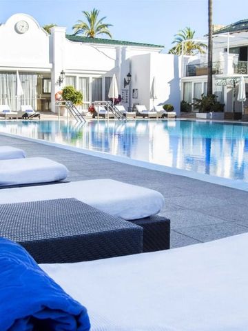 Sonnenliegen am Rande eines großen Pools in einer eleganten Hotelanlage