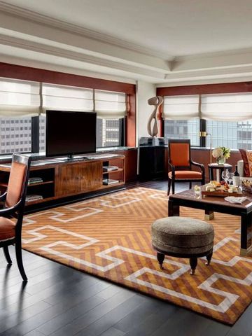 Luxuriöses Wohnzimmer in einer Suite mit stilvollen Möbeln und weitem Stadtblick