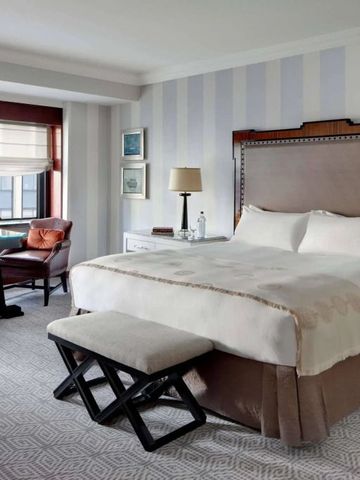 Elegantes Zimmer im Lotte New York Palace mit großem Bett und Sitzbereich