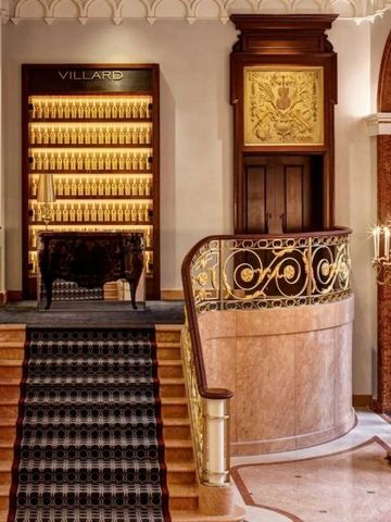 Opulenter Lobbybereich mit Marmortreppe und goldenen Details.