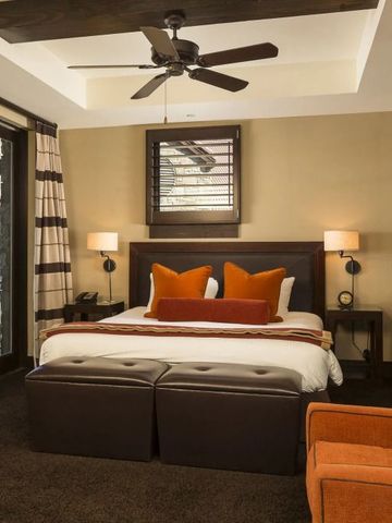 Geräumiges Schlafzimmer mit Deckenventilator und dekorativen Kissen