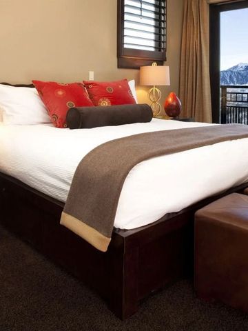 Luxuriöses Schlafzimmer mit Bergblick und großem Bett im Lumiere by Dunton Hotel