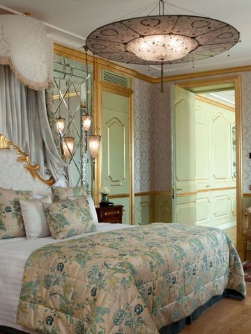 Opulent dekoriertes Hotelzimmer mit Baldachin und luxuriösen Möbeln.